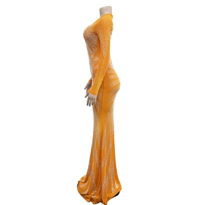 Detail of orange mesh maxi dress featuring long sleeves and sparkling silver rhinestones
