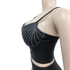 Détail d'un crop top noir avec motif de strass en coquille et fines bretelles