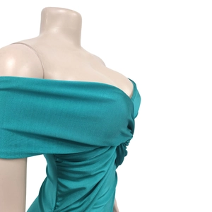 Close-up of ruched detail on a teal strapless bodycon dress with pleated texture