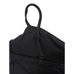 Détail d'une fine bandoulière réglable sur une robe noire ornée de strass