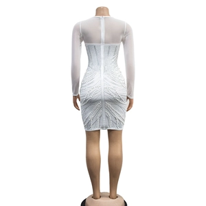 Detailed back view of white mini dress featuring mesh sleeves and rhinestone pearl patterns