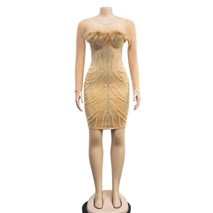 Detail of nude mesh mini dress with feather trim and sparkling rhinestones and pearls