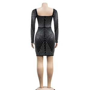 Detail view of black bodycon mini dress featuring silver rhinestone starburst pattern