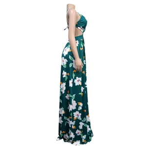 Detail of the waist cutout and white tropical floral print on a dark green maxi dress