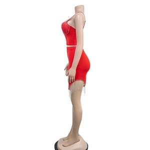 Détail d'un ensemble deux pièces rouge avec crop top strassé et jupe à franges