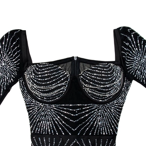 Close-up detail of silver rhinestones and sequins on high-stretch black bandage dress fabric