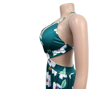 Detail of floral maxi dress showing side waist cut-out and deep v-neck on dark green fabric