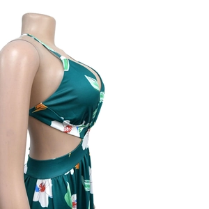 Detailed view of side cutout design and tropical floral print on dark green dress