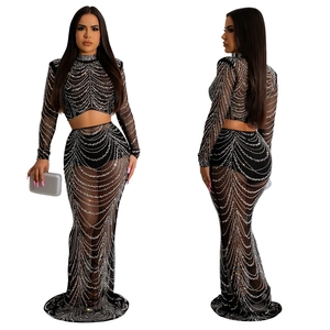 Détail d'une robe en résille noire avec strass argentés et manches longues sur modèle