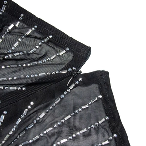 Close-up of black mesh fabric with silver rhinestones and invisible zipper detail