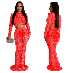 Détail du haut court et jupe longue en tulle rouge avec des strass scintillants