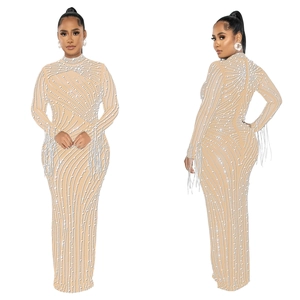 Detail of the sheer mesh dress featuring intricate white pearl patterns and fringe cuffs