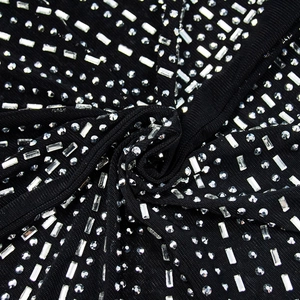 Detail shot of black mesh fabric with sparkling silver rectangular and round rhinestones