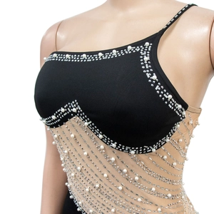 Détail de strass et franges de perles sur une robe sans manches en mesh noir