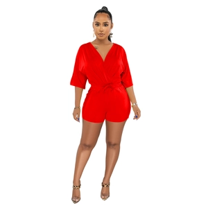 Detail view of red V-neck romper featuring a stylish waist tie and premium glossy fabric