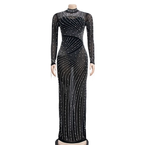 Detail of sheer black mesh dress with sparkling rhinestones and elegant long sleeves