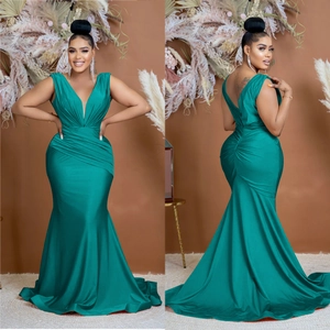 Detail view of dark green satin V-neck evening gown with elegant waist pleats