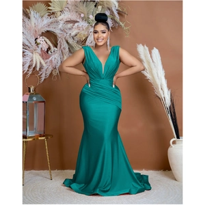 Detailed view of the deep V-neckline and elegant pleated waist of a dark green evening gown