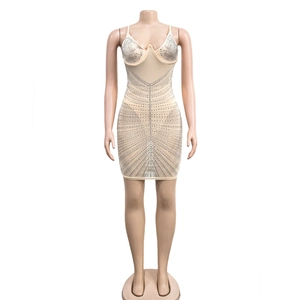 Detail of silver rhinestones in geometric patterns on a beige bodycon mini dress