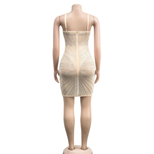Detail view of silver rhinestones and long back zipper on a beige mesh bandage mini dress
