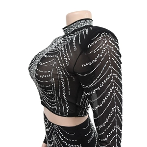 Détail du haut en résille noire avec des motifs géométriques en strass argentés