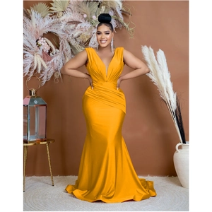 Close-up of elegant ginger yellow V-neck evening dress with sophisticated waist pleat details