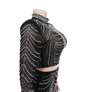 Détail du crop top en maille noire avec strass argentés et épaulettes rembourrées