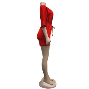 Side view of red short jumpsuit featuring mid-sleeves and an adjustable drawstring waistline