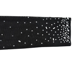 Detailed macro view of black sheer mesh fabric with shimmering silver rhinestones