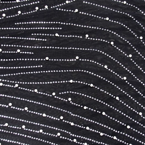 Detailed view of black mesh fabric with streamlined rhinestones and pearl embellishments