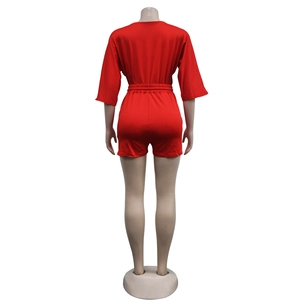 Rear view of bright red short romper with elastic waist and half sleeves on mannequin