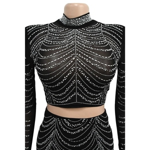 Détail d'un ensemble deux pièces en mesh noir avec strass argentés et col montant chic