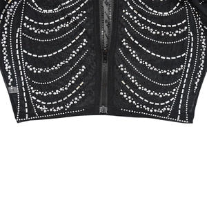 Détail du haut en résille noire avec strass à motif côtes et fermeture éclair