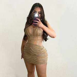 Detailed close-up of champagne gold rhinestone dress with mesh panels and boning