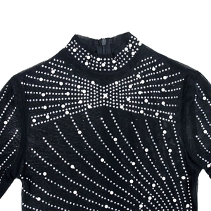 Detail of sheer black mesh top featuring rhinestone bow and faux pearl embellishments