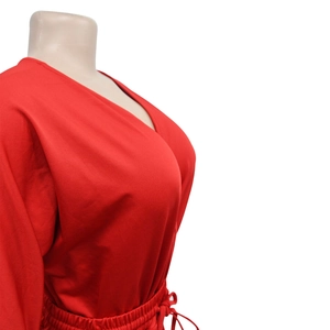 Detail of red V-neck jumpsuit with adjustable drawstring waist on a mannequin