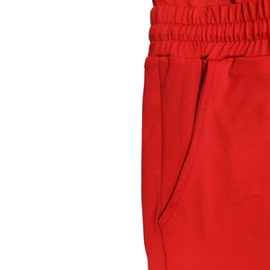 Detail of red playsuit waist with elastic band and side pocket on white background