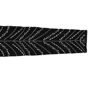 Détail des manches en résille noire avec des motifs géométriques en strass argentés