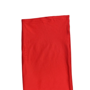 Detail of red V-neck jumpsuit showing double-stitched sleeve cuffs and premium knit texture