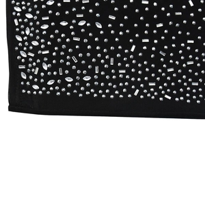 Detailed view of shimmering silver rhinestones in various shapes on black mesh dress fabric