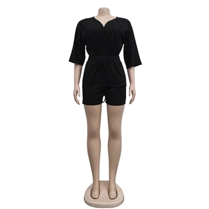 Detail of black V-neck romper featuring an adjustable drawstring waist and mid-length sleeves