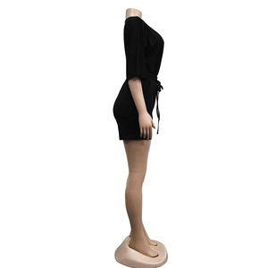 Side view of black short-sleeve romper with waist drawstring and knit fabric texture