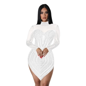 Close-up of white bodycon dress with sparkling rhinestones and sheer mesh sleeves