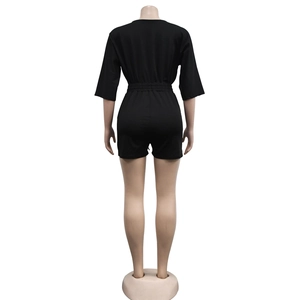 Back view of a black v-neck romper with half sleeves and elastic waist on model