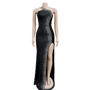 Detail of elegant black one-shoulder dress with sparkling rhinestones and side slit