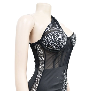 Detail of black one-shoulder mesh dress featuring intricate silver rhinestone patterns