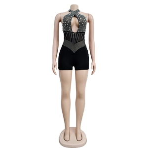 Detail of black mesh jumpsuit featuring intricate rhinestone embellishments and faux pearls