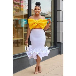 Detail of a yellow oversized bow tube top paired with a white ruffled mermaid skirt