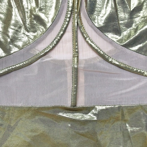 Close-up of gold metallic fabric and sheer mesh paneling on a sleeveless dress