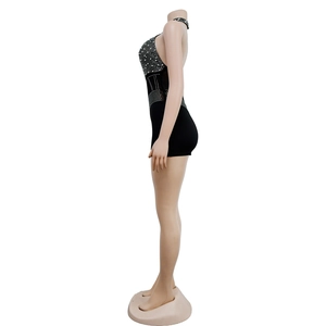 Close-up of black sleeveless romper featuring silver rhinestones and halter neck design